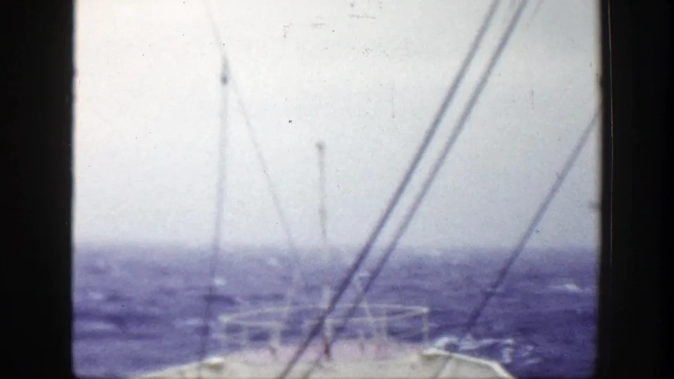 Deck-level 1948 home-movie view of a vessel bow and rigging against blue choppy water, likely near New York per metadata.