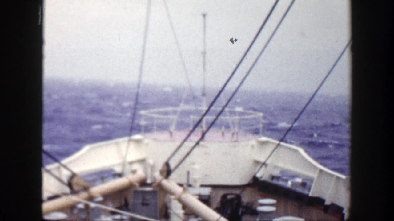 1948 8mm deck view from a ship, looking over the bow and rigging toward rough ocean water.