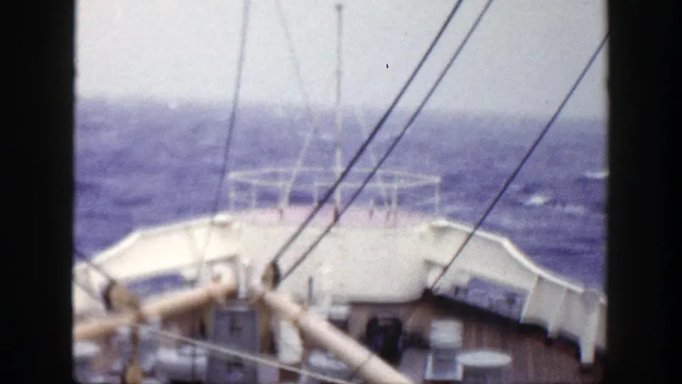A forward-facing 1948 shipboard view shows railings and rigging against rough blue ocean.