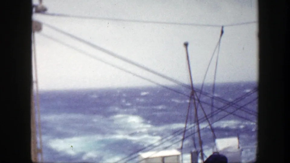 1948 8mm shipboard view near New York showing rough ocean water, whitecaps, and rigging silhouetted in the foreground.