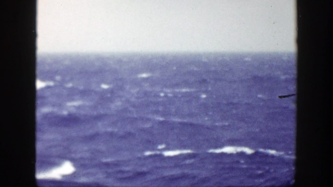 1948 8mm home-movie view of rough blue ocean water with whitecaps and a pale horizon, framed by dark film edges.