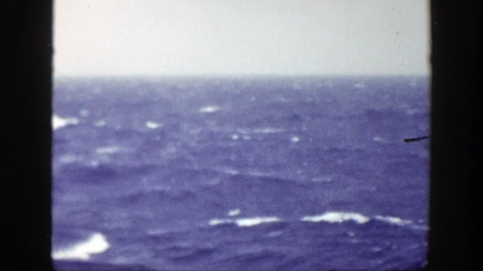 1948 8mm home-movie view of rough blue ocean water with whitecaps and a pale horizon, framed by dark film edges.