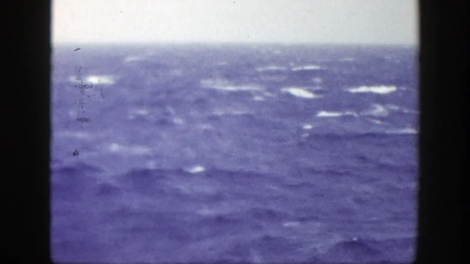 1948 8mm home-movie frame showing choppy ocean water, a faint horizon, and visible scratches or dust in the scan.