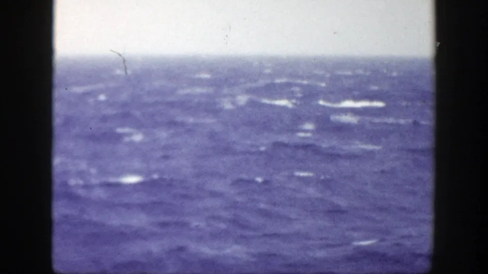 1948 8mm home-movie frame showing rough blue ocean water and pale overcast sky, with no people visible.