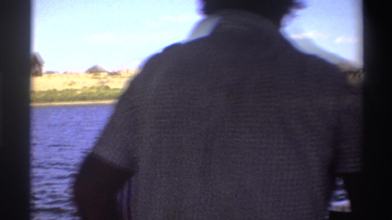 1969 Nigeria frame from a boat, with two adults seen from behind or side-on as they face the river and distant shoreline.