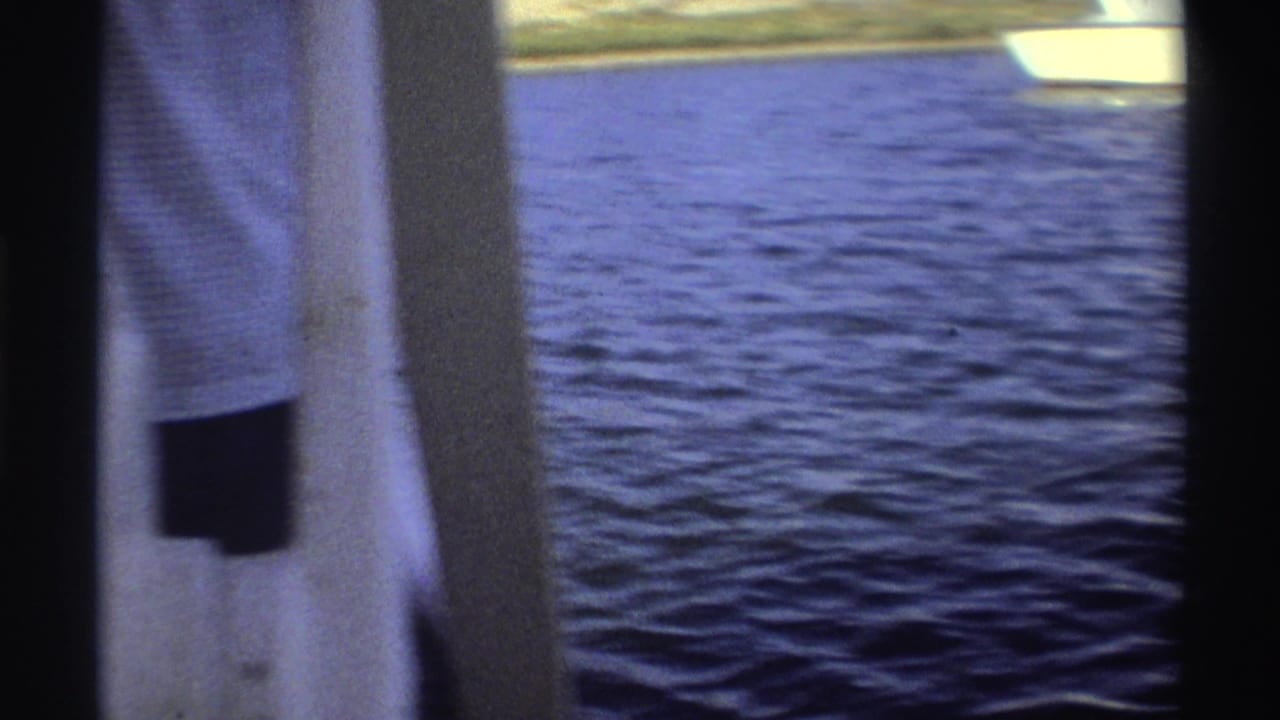 Adult on a boat with open water behind them during a fishing catch.