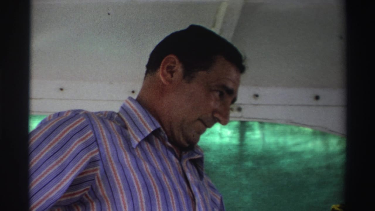 Man in a striped shirt looking down inside a boat.