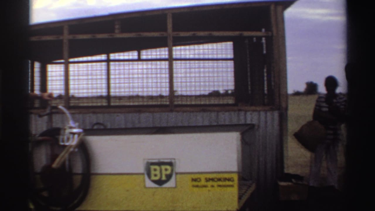 BP fuel station frontage with no-smoking sign, bicycle edge, and people partly visible beside the building.