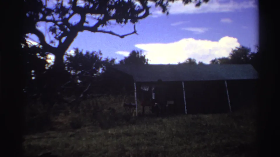 The final frame shows the large tent and grassy clearing, with the bucket-carrying man partly obscured near the entrance area.