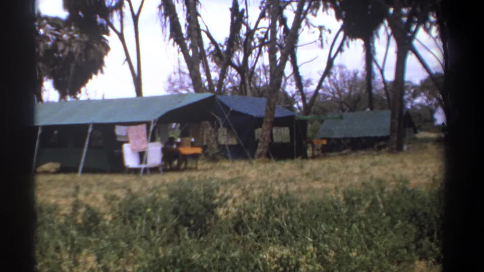 A wider Kenya 1969 camp view shows green canvas tents among trees and dry grass, with a small table near the tent opening.