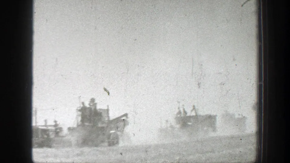 Distant field machinery in 1939 California moves through dust, with several people visible on or near the equipment.