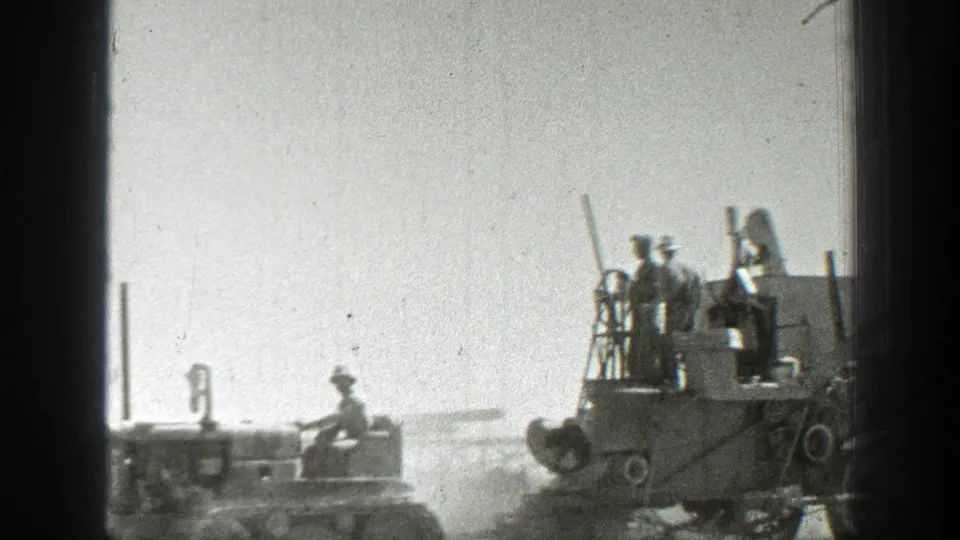 1939 California harvest footage showing operators on a field machine at right, with more machinery faintly visible through dust behind it.