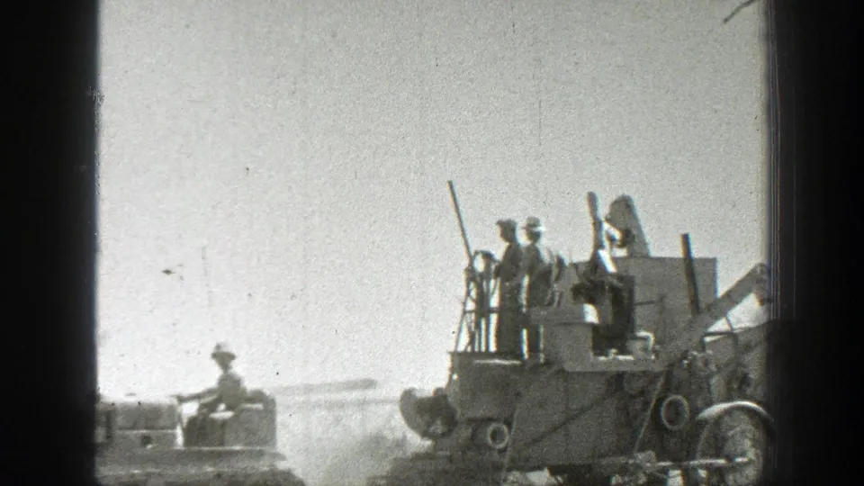 1939 California 8mm frame showing workers on harvesting machinery with a tractor nearby in a bright, dusty field.