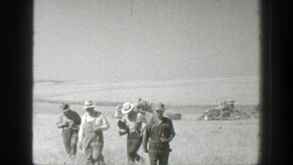 The group begins walking through a California field in 1939 home-movie footage, with distant figures and machinery near the horizon.
