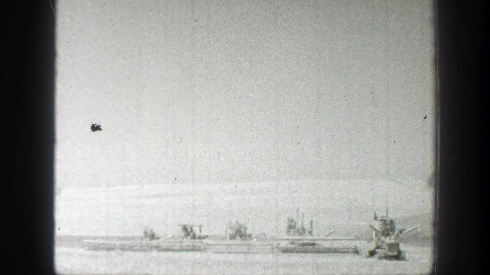 1939 California harvest scene with multiple distant machines spaced across a broad field under bright daylight.