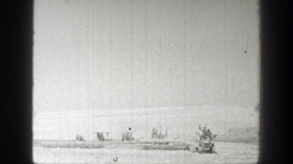 1939 California home-movie frame with several pieces of farm equipment spread across a sunny field.