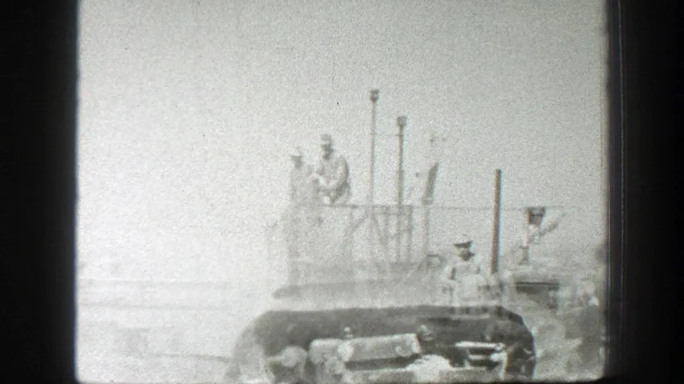 Dust partly obscures a tracked vehicle and harvest machinery as workers continue operating in the California field.