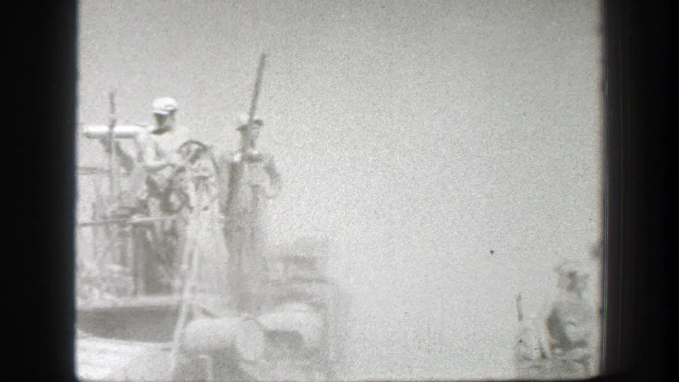 Workers remain visible on elevated combine platforms as dust softens the 1939 California wheat harvest scene.