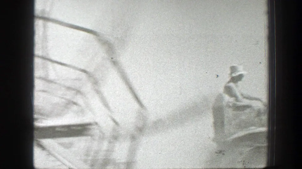 A man in a brimmed hat appears to ride or operate farm machinery in a 1939 California field, partly obscured by motion blur.