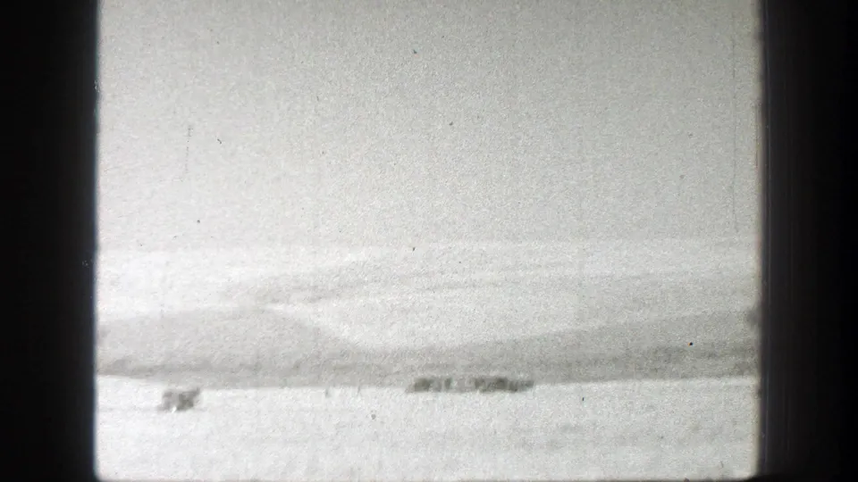 Wide 1939 California farm landscape with distant agricultural equipment or vehicles crossing a dry field.