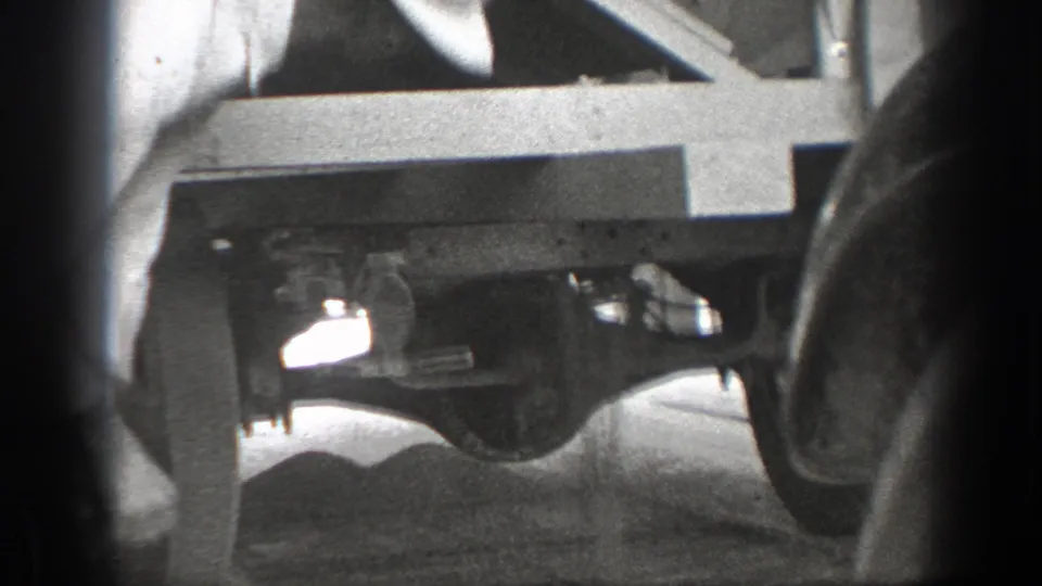 A partly visible person appears to lean near the underside of a stopped truck in this 1939 California roadside scene.