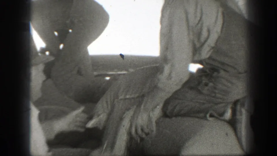 The final 1939 California frame shows a worker bent low beside a large sack, with another man standing near the work area.