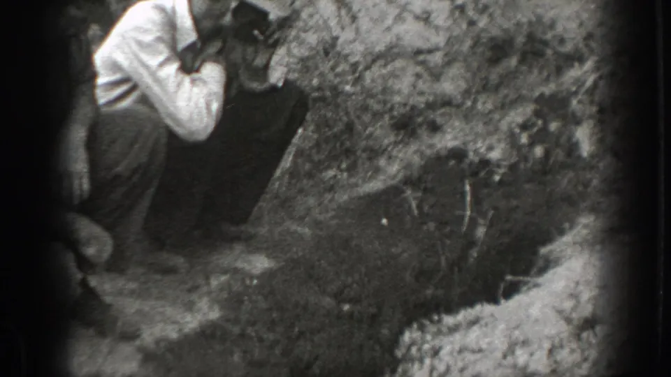 1939 California 8mm frame showing a man in suspenders near a rough wooded bank, with another partial figure at the edge.
