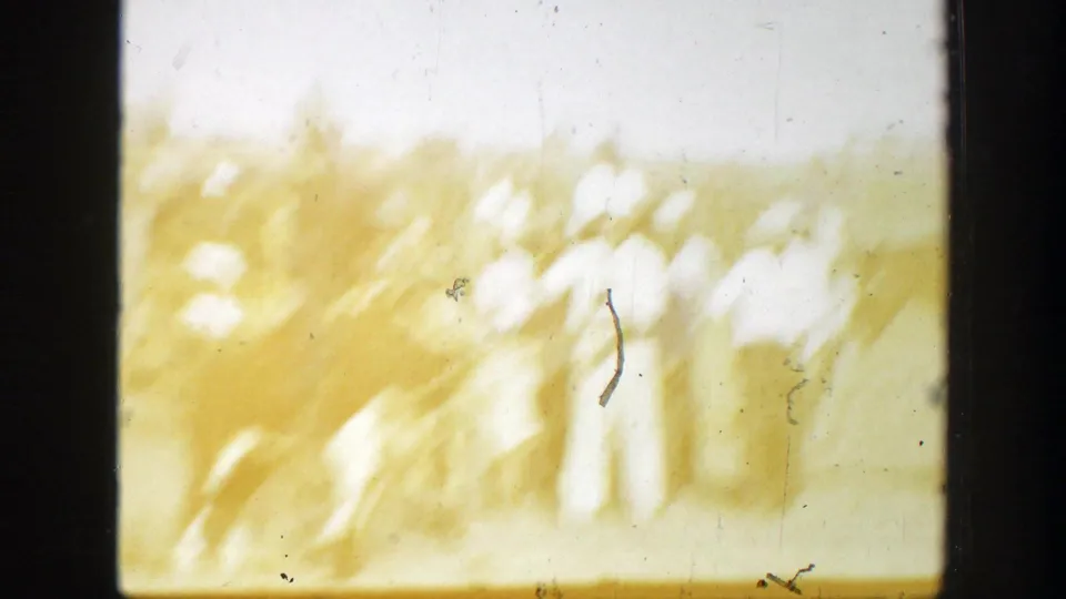 1939 California 8mm frame showing a blurred bull and rider crossing a sunlit dirt rodeo arena.