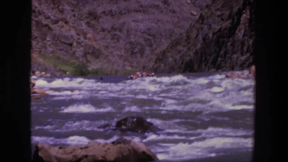 1969 Utah 8mm frame showing rafters farther down a rapid, filmed from shore across the river.