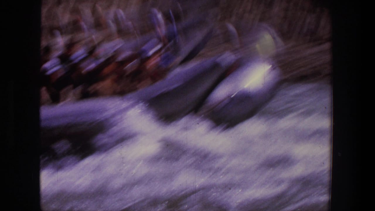 Blurred raft entering foamy whitewater with passengers barely visible.