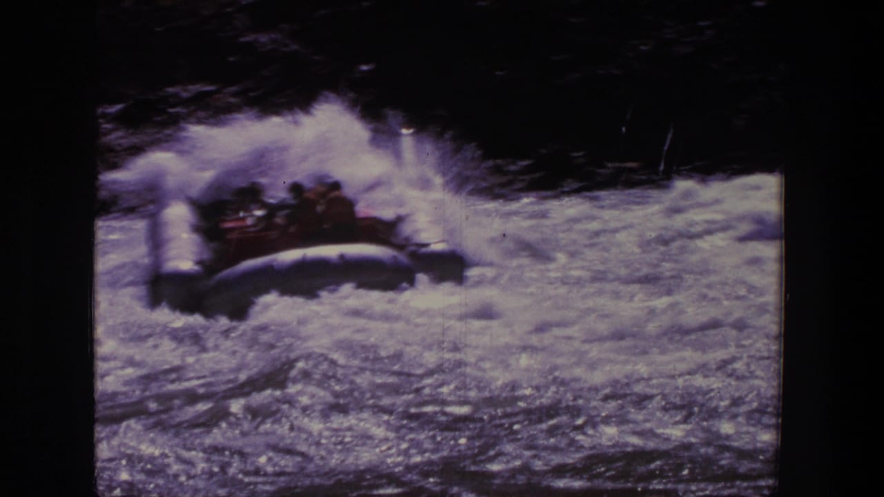 Rubber raft carrying several people bounces through whitewater in the Utah home-movie footage.