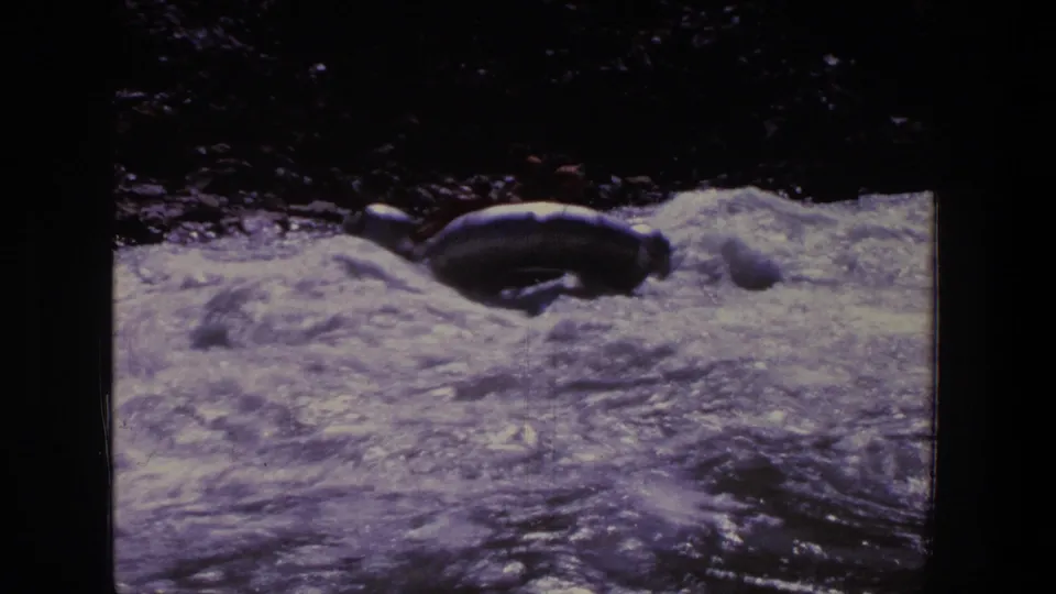 The raft is partly hidden by waves as it moves through a rough section of Utah whitewater.