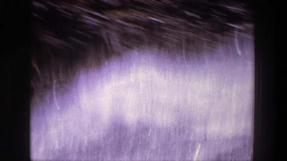 A close, motion-blurred 8mm frame of whitewater spray and river turbulence during the rafting run.