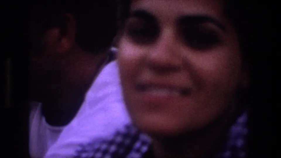 Soft-focus Utah 1969 8mm close-up of a smiling woman with sunglasses on her head, framed tightly near another person.