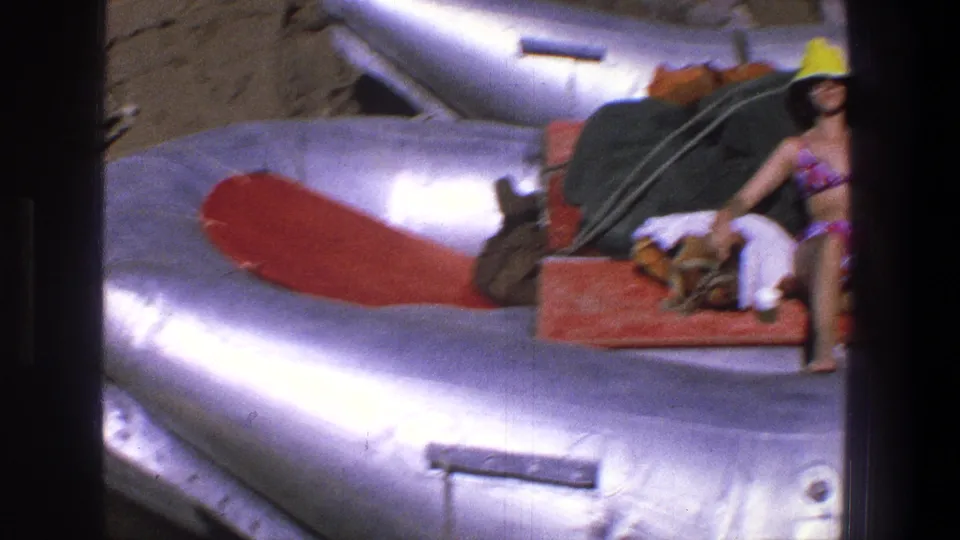 A partial frame shows the woman seated on the raft at the edge of a silver inflatable boat during the Utah river outing.