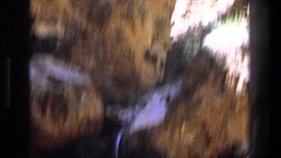 Motion-soft 1969 Utah 8mm frame of water and brown canyon rock, with highlights streaking across the scene.