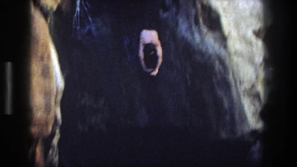 1969 Utah 8mm frame showing the jumper dropping beside a canyon wall toward the pool.