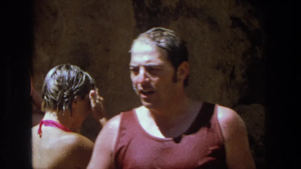 Near the end of the 1969 Utah home-movie clip, the man in the red tank top turns as the woman behind him raises a hand in the cave-like area.