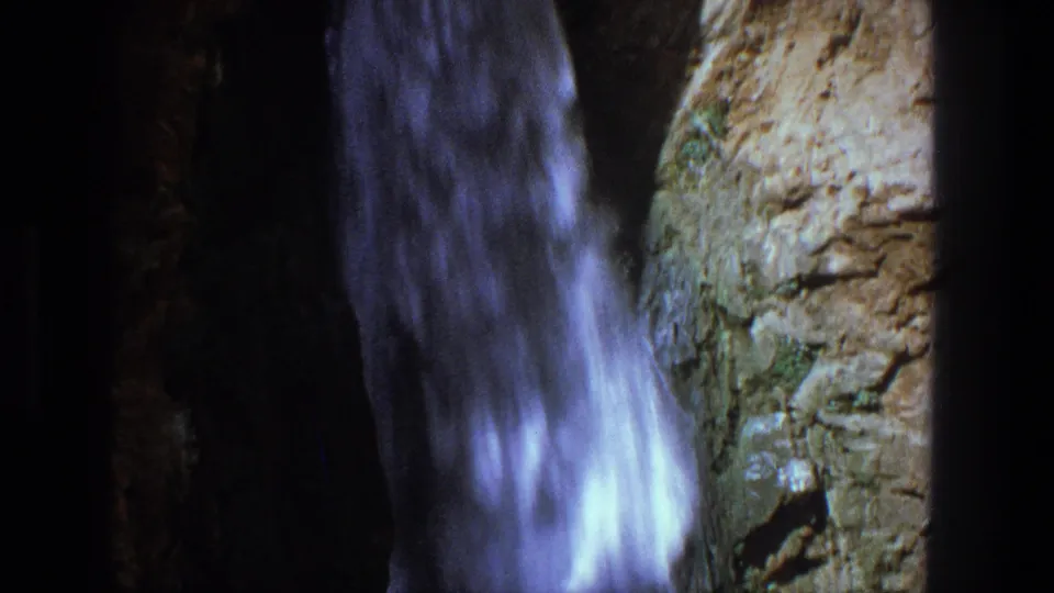 1969 Utah frame showing rushing water beside rugged tan and brown rock near the end of the camera pan.