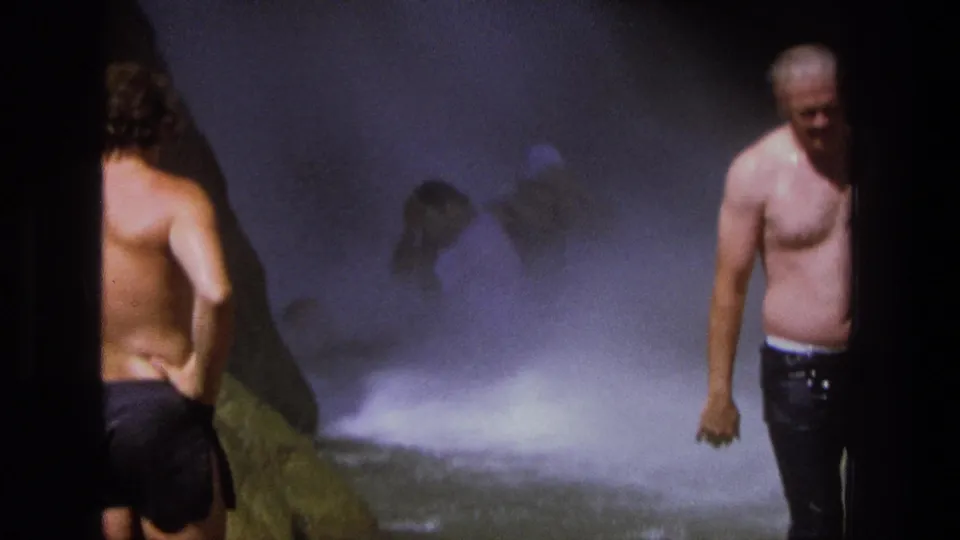A 1969 Utah 8mm frame shows men at the side of a waterfall, with bright mist and dark film edge marks.
