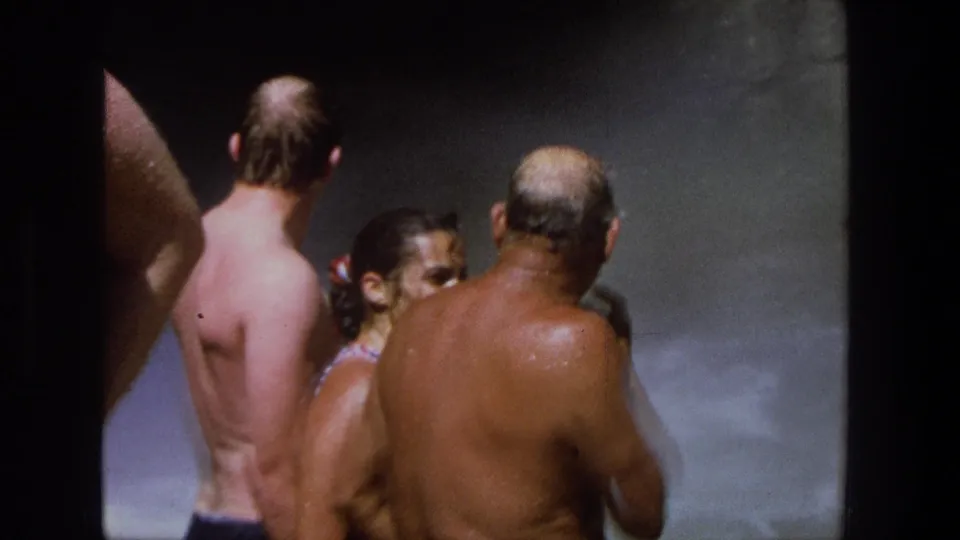 1969 Utah 8mm frame of swimmers seen mostly from behind in a misty pool or waterfall setting.
