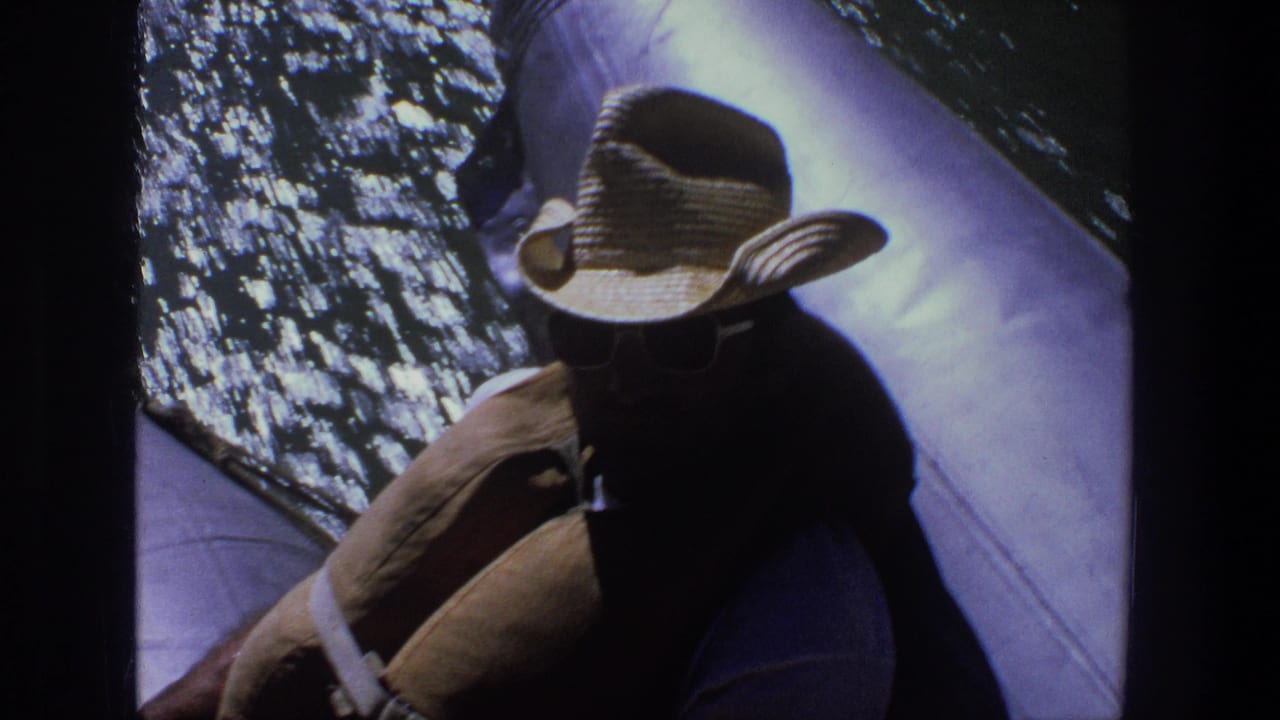 Boat passenger in a straw cowboy hat seen close to shimmering water.