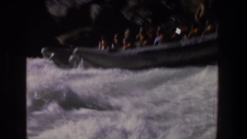 1969 Utah rafting footage shows a silver inflatable raft carrying passengers through churning white water.