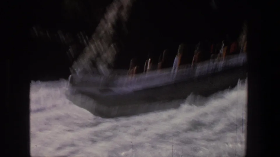 The silver raft appears blurred by speed and camera movement as it hits a turbulent rapid in Utah.