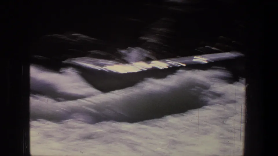 A silver raft is tossed through bright foam and shadowed rapids in this Utah home-movie frame.