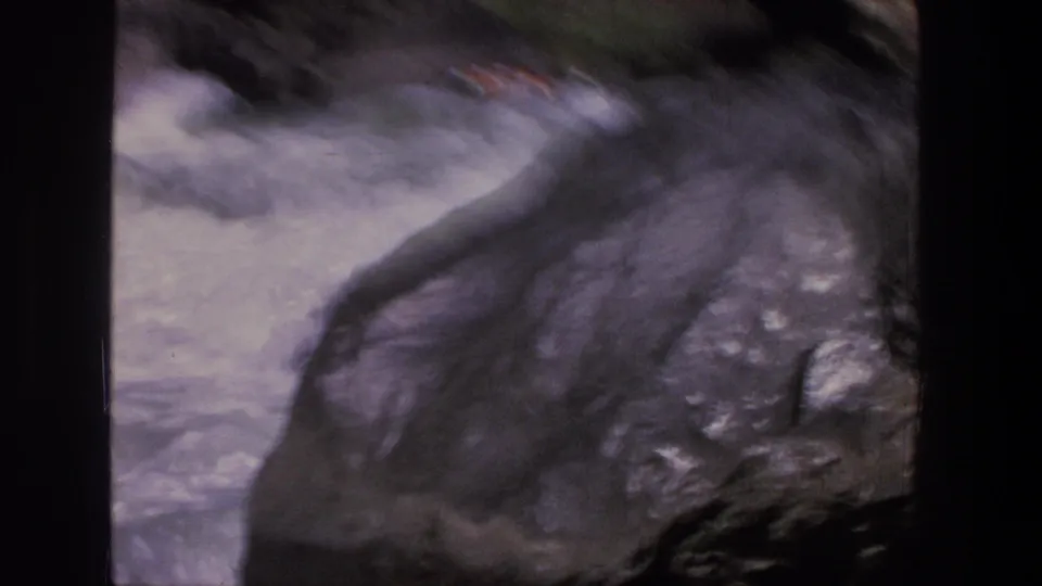 The 8mm frame shows a motion-blurred raft in rough Utah whitewater, with dark rocks dominating the foreground.