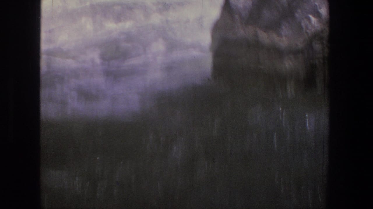 Blurred whitewater and dark riverbank forms within an 8mm film frame.