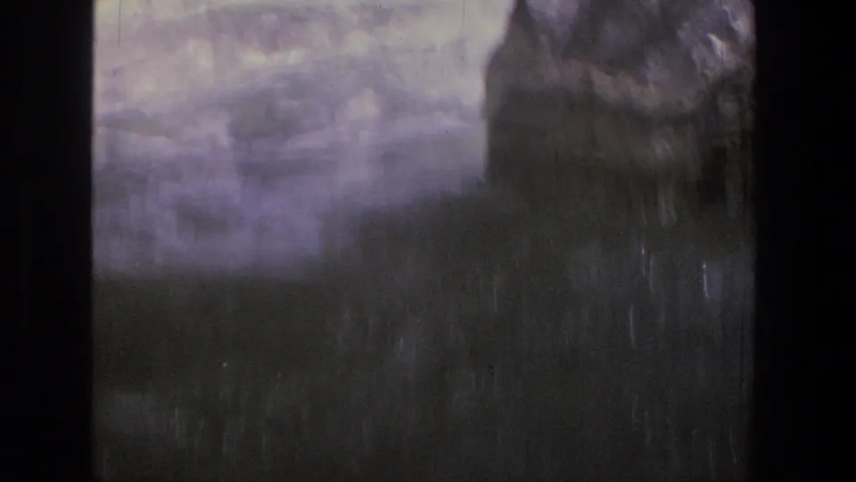 Soft, partially obscured 8mm frame of rushing river water and dark canyon-side shapes in Utah home-movie footage.