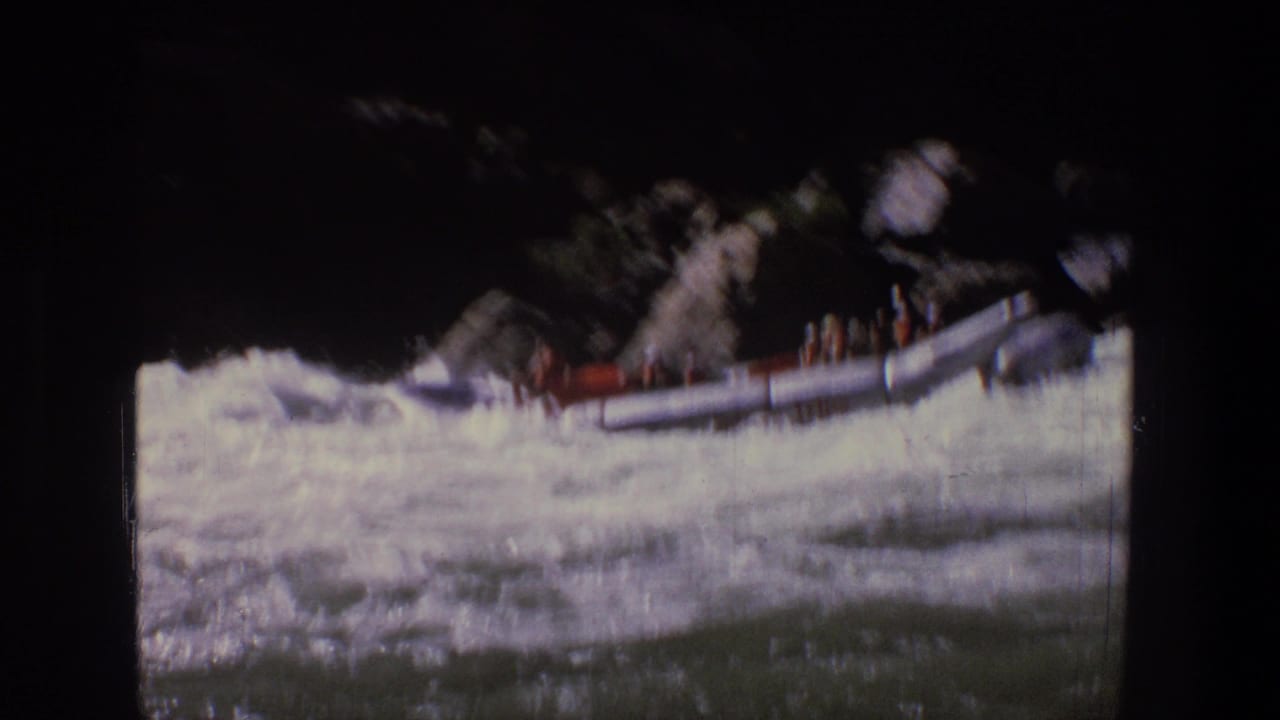Inflatable raft rides through foamy rapids with passengers visible along the side.