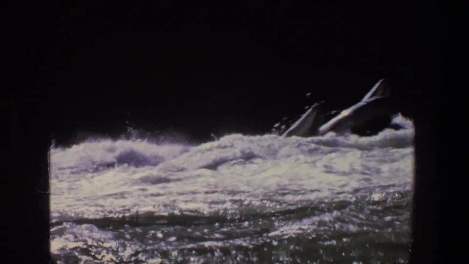 1969 Utah 8mm frame showing an inflatable raft in foamy river current, with people appearing as dark silhouettes.